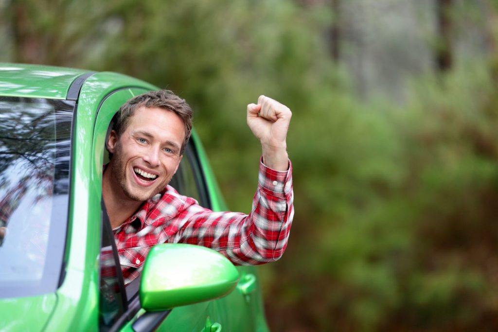 Green energy biofuel electric car driver happy and excited. Man